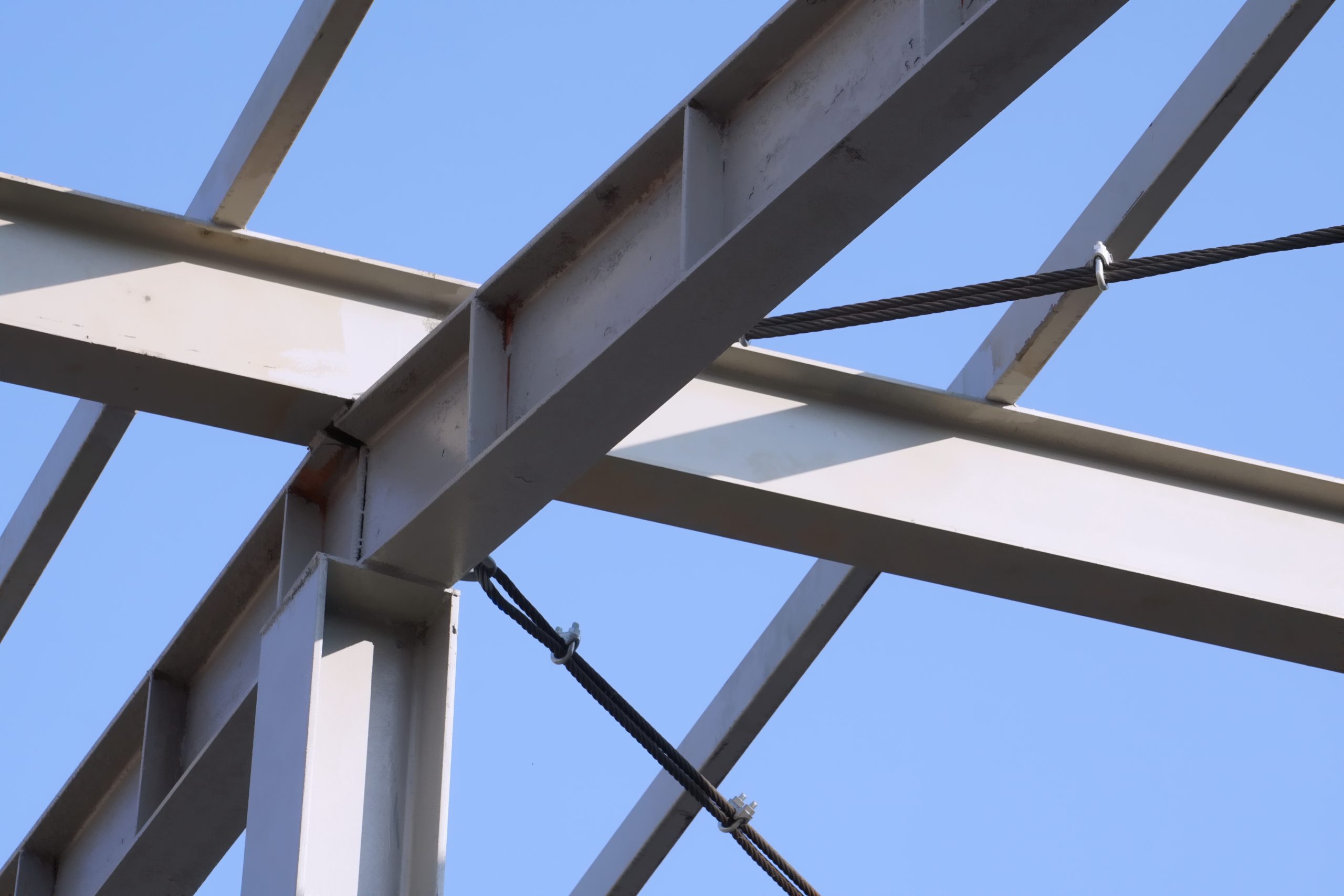 Selective focused structure steel beam prepared support roofing of building. Blue sky background. Concept of steel beams, structure, bar, metal pillar, metal sting, building construction, skeleton